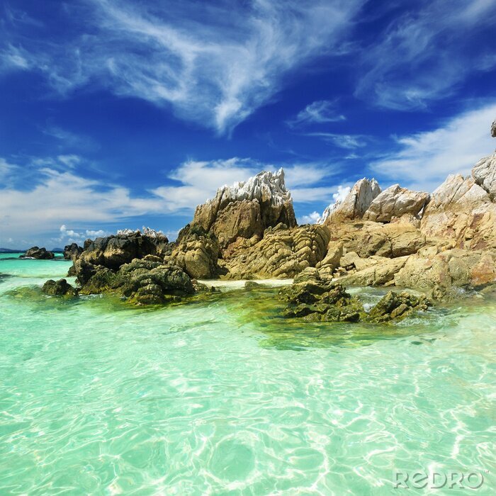 Fotobehang Helder water en rotsen bij de zee
