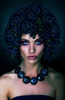 Fotobehang Interessant portret van vrouw met blauwe druiven