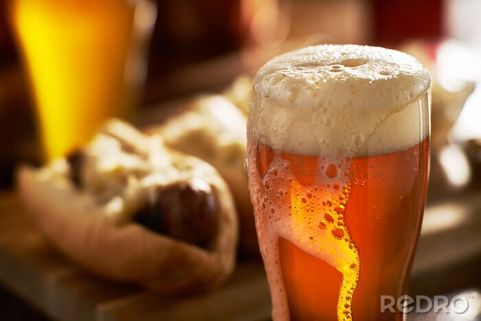 Fotobehang IPA bier met overvolle schuimende hoofd in mok geserveerd met bratwursts