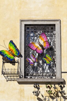 Fotobehang Iron window decorated with metal colourful butterfly ornaments