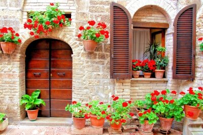 Fotobehang Italiaanse huis voorzijde met kleurrijke bloembakken