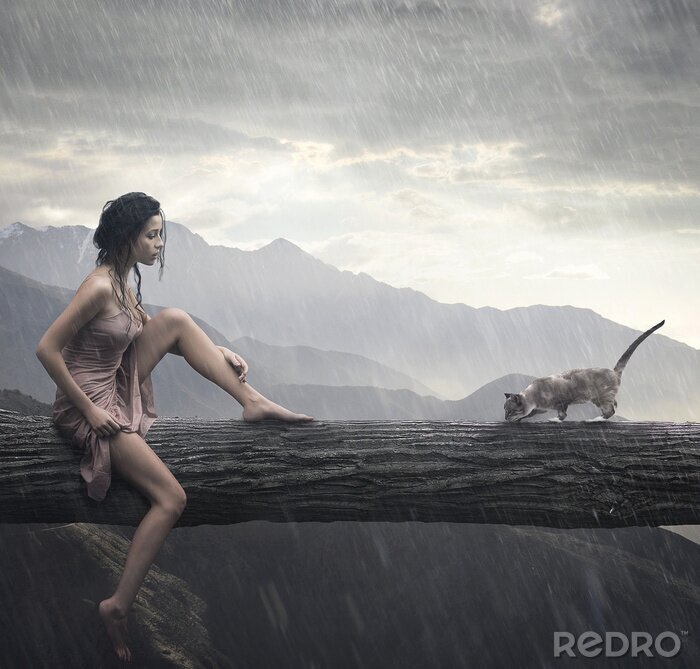 Fotobehang Jonge vrouw en kat op een boomstam