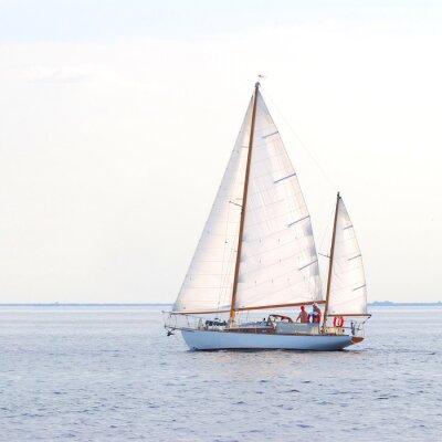 Fotobehang Kalme zee en een zeilboot