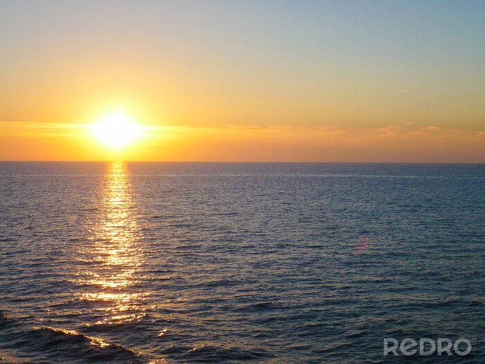 Fotobehang Kalme zee en zonsondergang