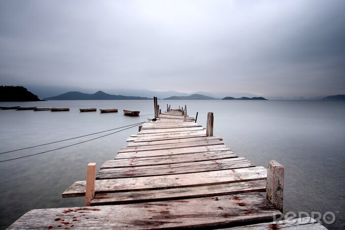 Fotobehang Kijkt uit over een pier en een boot, donkere toon.