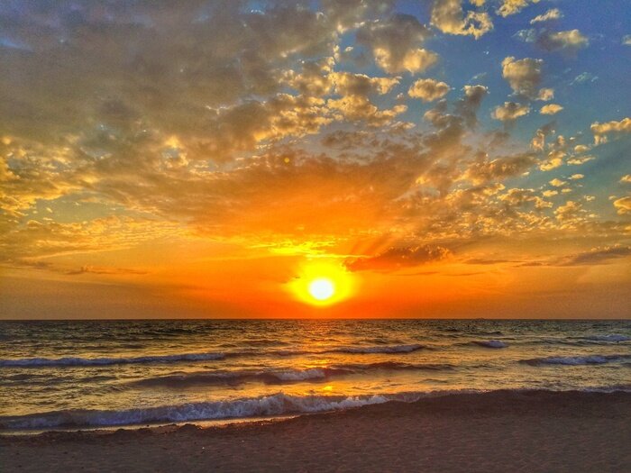Fotobehang Kleine golven op de zee bij zonsondergang