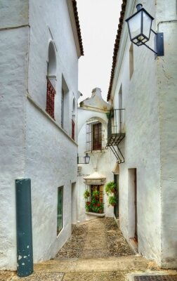 Fotobehang Kleine smalle straat in Spaanse stad met witte huizen