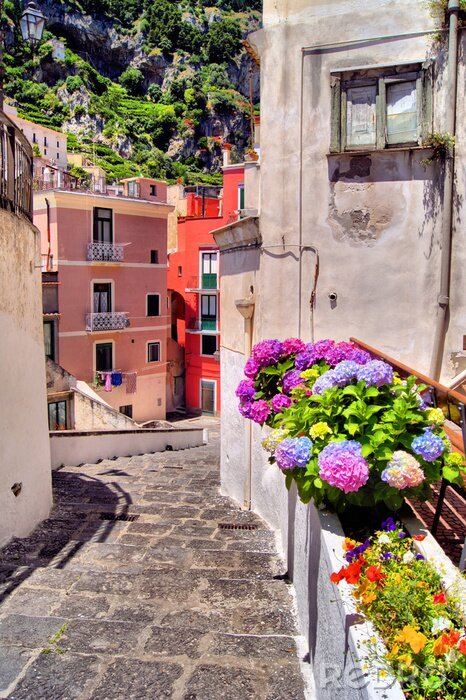 Fotobehang Kleurrijke bloem omzoomde straat in een kustplaatsje in Italië