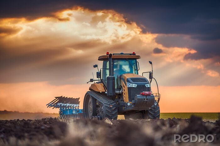 Fotobehang Landbouwer in tractor voorbereiding van grond met cultivator