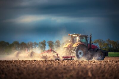 Fotobehang Landbouwer in tractor voorbereiding van grond met zaaibed cultivator