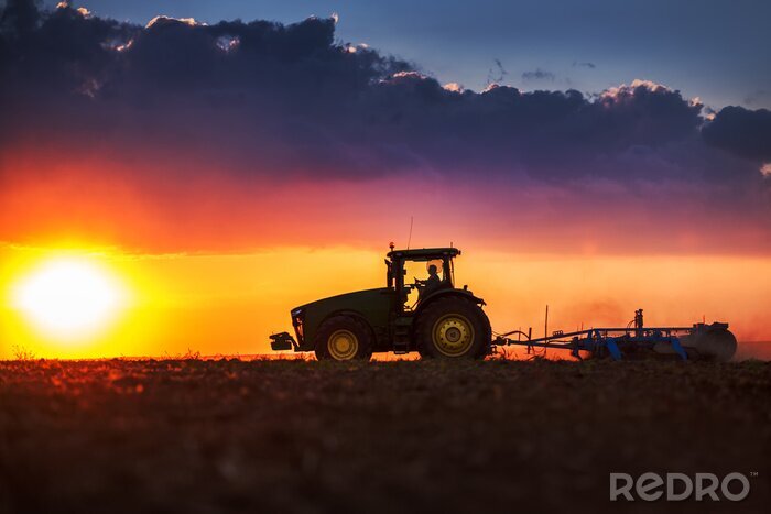 Fotobehang Landbouwer in tractor voorbereiding van grond met zaaibed cultivator