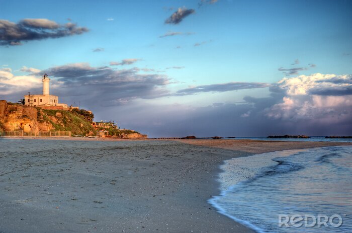 Fotobehang Landschap met een strand en een vuurtoren