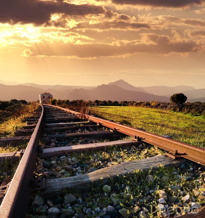 Fotobehang landschap voor een oude spoorweg verlaten bij de zonsondergang