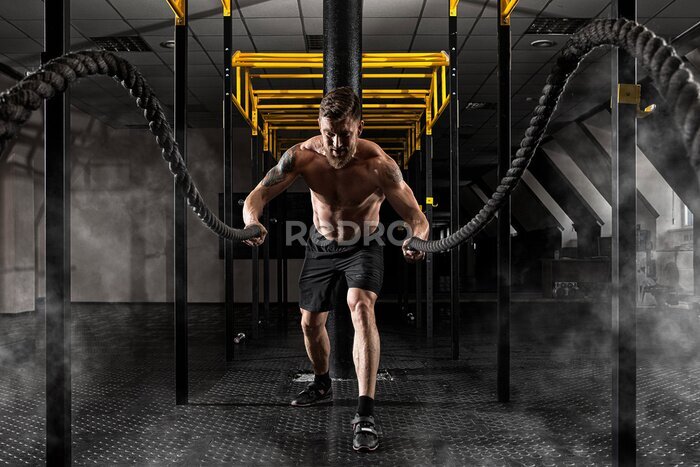 Fotobehang Mens die met slagkabels uitwerkt bij gymnastiek