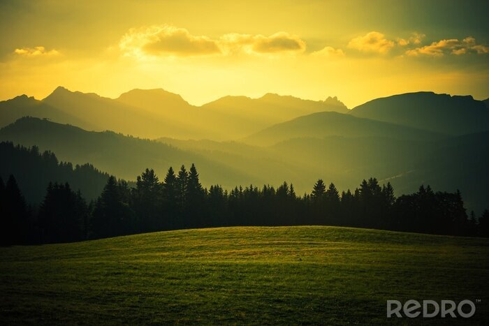Fotobehang Nevelige bergen in gouden stralen