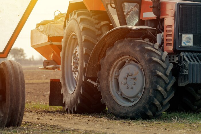 Fotobehang Old red agricultural tractor with trailer on dirt countryside road