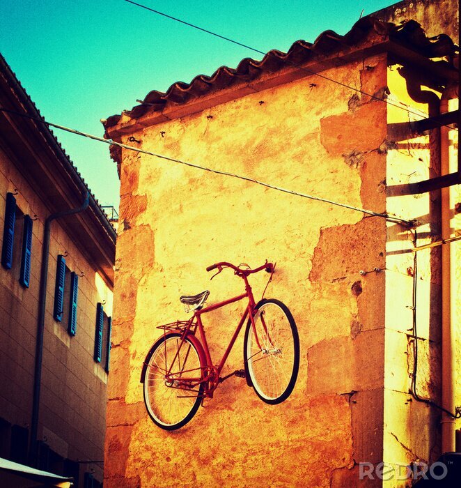 Fotobehang Oude fiets aan de muur