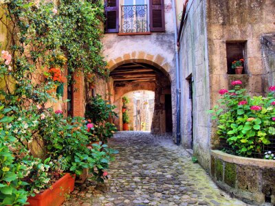 Overspannen geplaveide straat in een Toscaans dorp, Italië