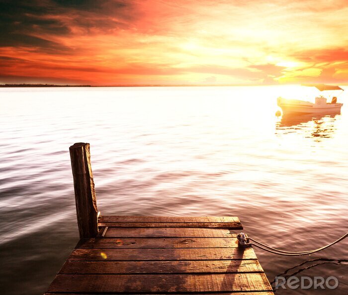 Fotobehang Pier aan het meer met een boot