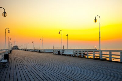 Fotobehang Pier op de achtergrond van de ondergaande zon