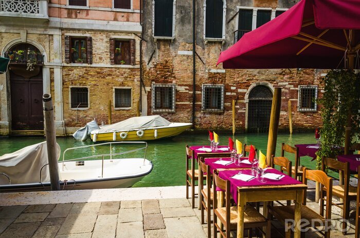 Fotobehang Restaurant op Venetiaans kanaal tussen oude huizen in Venetië, Italië.