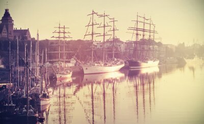 Fotobehang Retro getinte foto van zeilschepen bij zonsopgang.