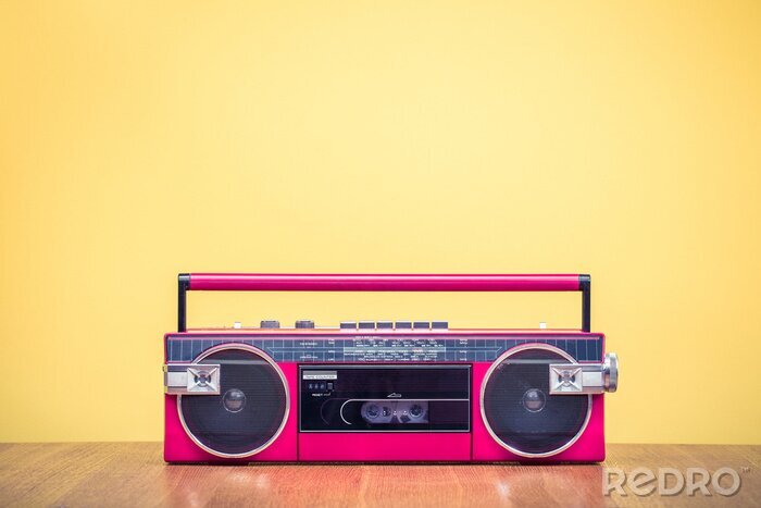Fotobehang Retro verouderde rode draagbare stereo radio cassette recorder van 80s voor geel achtergrond. Vintage oude instagram stijl gefiltreerde foto