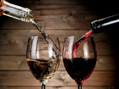 Rode en witte wijn gieten op hout achtergrond