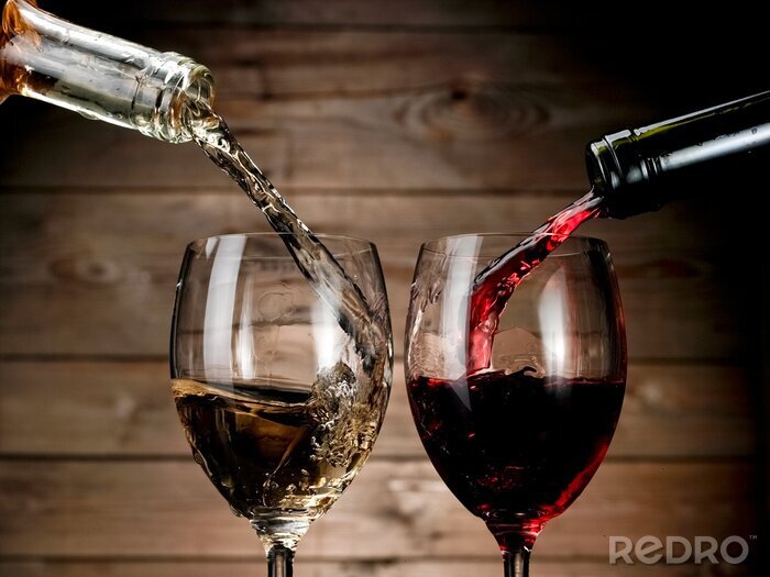 Fotobehang Rode en witte wijn gieten op hout achtergrond
