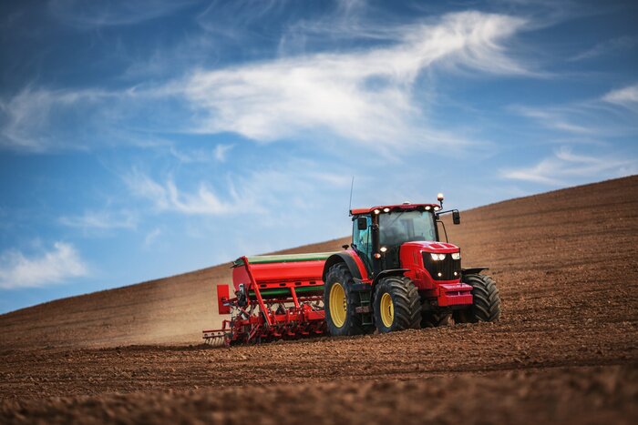 Fotobehang Rode tractor op het veld