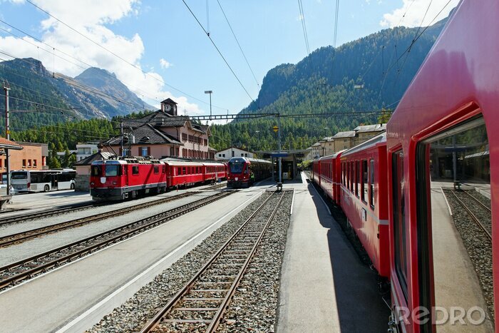 Fotobehang Rode treinen in een berglandschap