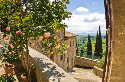 Fotobehang Rozen op balkon in San Gimignano, Toscane landschap achtergrond
