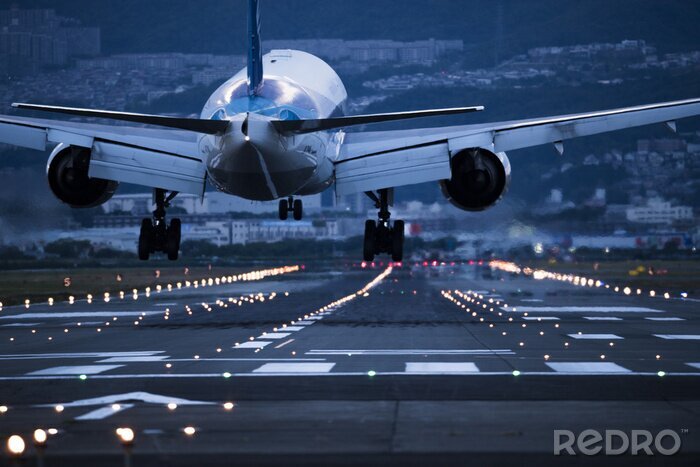 Fotobehang 'S Avonds gaat het vliegtuig op de landingsbaan landen