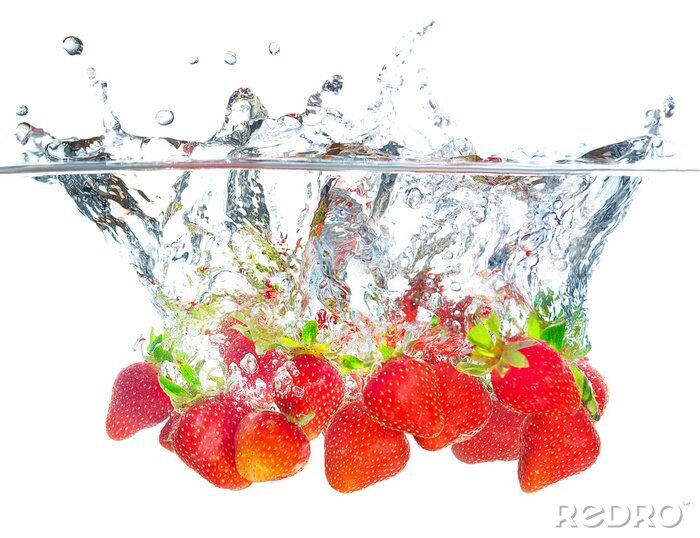 Fotobehang Sappige aardbeien gedoopt in water