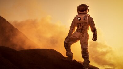Silhouet van de Astronaut staande op de rotsachtige berg van de buitenaardse rode planeet / Mars. First Manned Mission op Mars. Ruimteverkenning, kolonisatie.