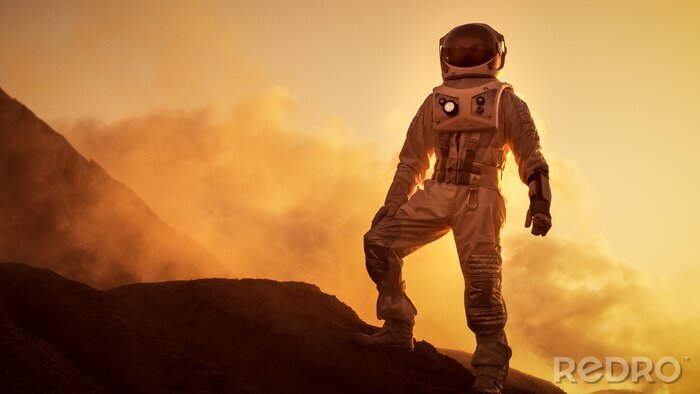 Fotobehang Silhouet van de Astronaut staande op de rotsachtige berg van de buitenaardse rode planeet / Mars. First Manned Mission op Mars. Ruimteverkenning, kolonisatie.