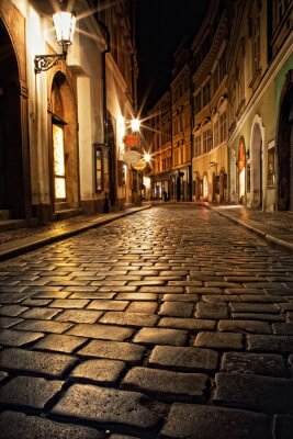 smal steegje met lantaarns in Praag bij nacht