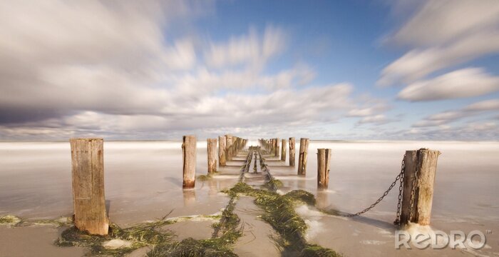 Fotobehang Sporen op een pier boven de zee