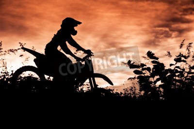 Fotobehang Status van silhouate motorcross springen over het oranje licht van de zonsondergang achtergrond.