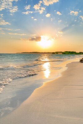 Strand en zee met ondergaande zon