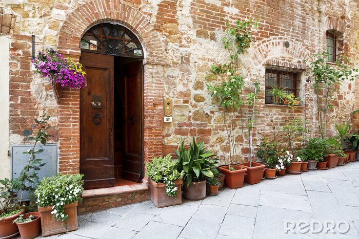 Fotobehang The cobbled streets of the beautifully decorated walls with colorful flowers, Tuscany, Italy