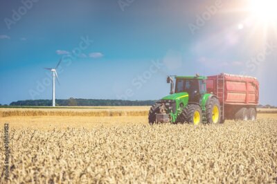Fotobehang Tractor auf Feld mit Sonne