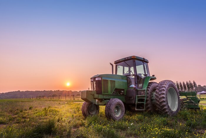 Fotobehang Tractor op een gebied op een Maryland boerderij bij zonsondergang