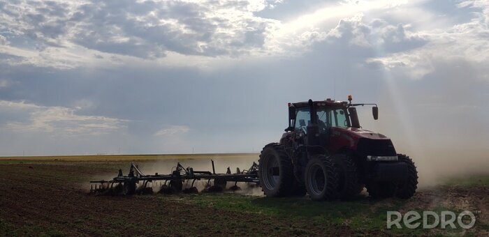 Fotobehang tractor plowing field