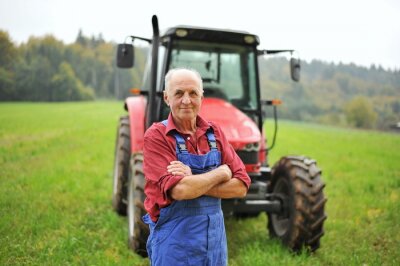 Trotse boer staat voor zijn rode tractor