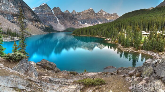 Fotobehang Turquoise water van het meer naast de bergen