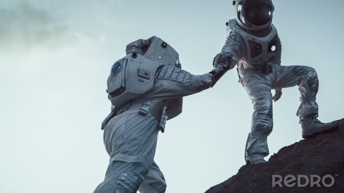 Fotobehang Twee astronauten die elkaar helpen