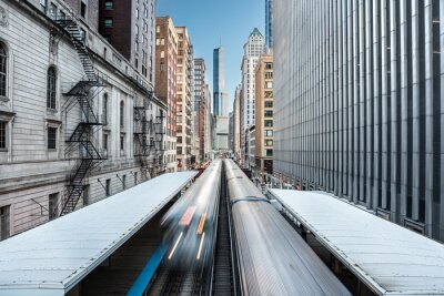 Fotobehang Twee treinen van het metrosysteem van Chicago over de verhoogde spoorlijn in een wolkenkrabberskloof in het Loop-district, Chicago, Illinois, Verenigde Staten