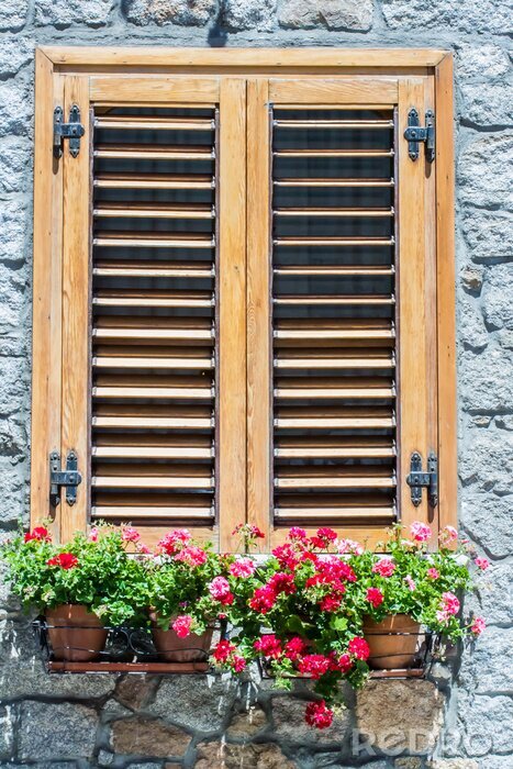 Fotobehang Typische venster van een stenen huis met houten luiken gesloten en