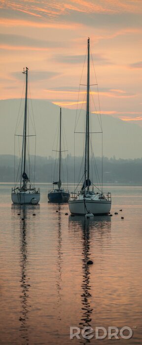 Fotobehang Varende schepen in de stralen van de ondergaande zon
